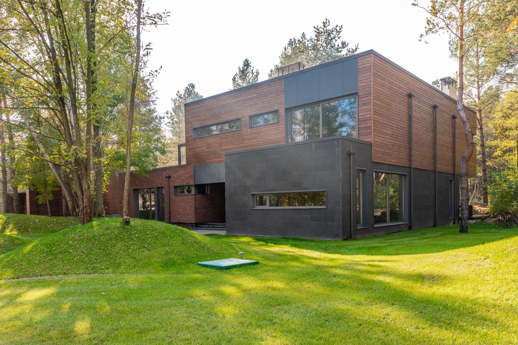 Contemporary stone and wood architecture framed by trees; visual inspiration, not the practice building